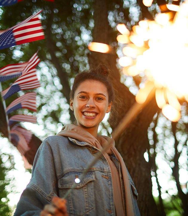 A person with sparklers and flags celebrating the USA 250 Anniversary at one of the Marion Illinois Events